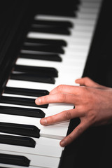 Obraz premium A close up on a woman's hand on a black and white keyboard playing piano