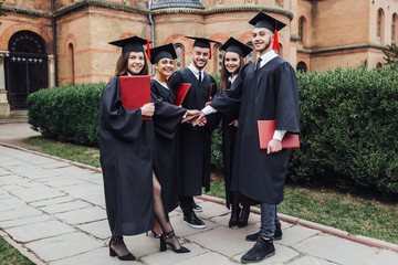 Group graduation of students looking very happy with diploma!