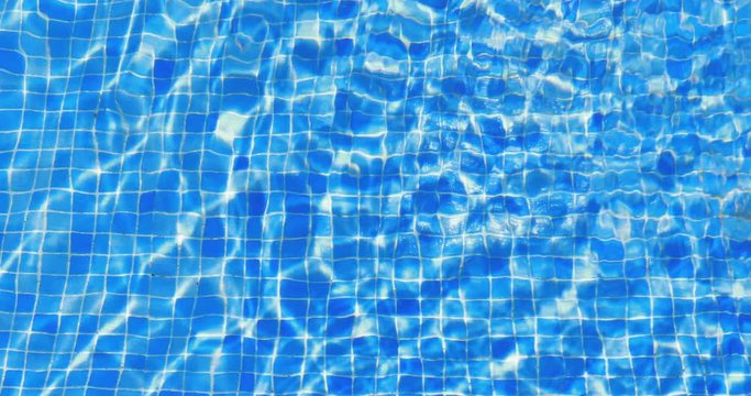 water ripples in swimming pool, blue tile background, 4k loop-ready