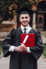 Young handsome graduated man in mantle holding degree!