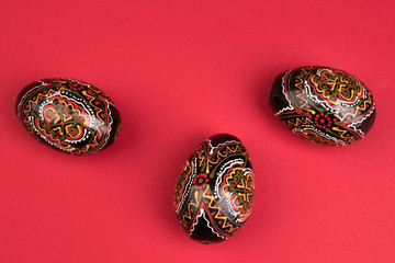 Happy Easter. Painted eggs on red background. Top view. Copy space for text.