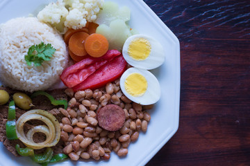 Brazilian food dish - Beans, rice, meat, eggs, salad