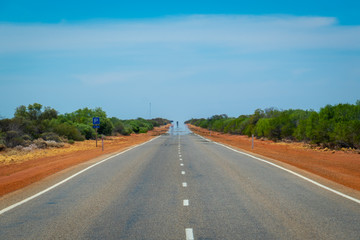 Mirage on endless straight road leading through Australian Bush