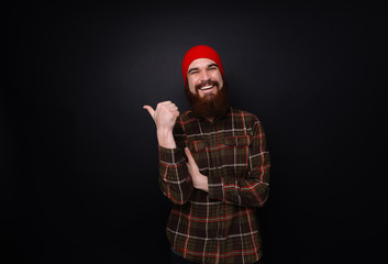 Happy bearded man showing thumb up and smile. Isolated studio shot on dark background