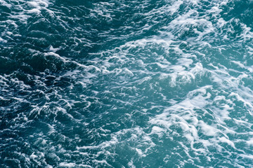 Turquoise and blue ocean water with bubbles and waves as a nature background