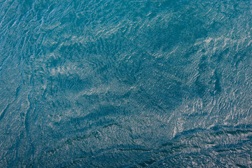 Turquoise ocean water with pattern and texture is small waves as a nature background