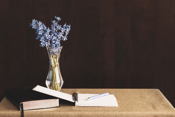 Bible and journal placed on a table with flowers in vase; Bible and journal for daily devotions