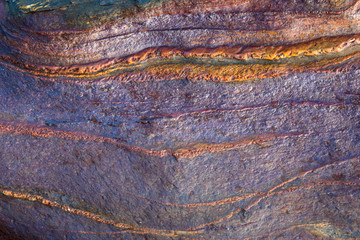 Smooth stone with purple and orange pattern, as a nature background