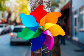 Colorful and rainbow colored paper windmill in street