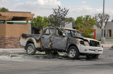 Burned car left abandoned in the parking lot. Ruined, melted, destroyed automobile.  Car insurance claim.