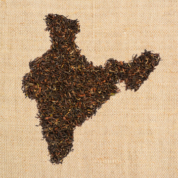 Loose black tea. The contour of the India is made of Indian Assam tea on homespun linen canvas background