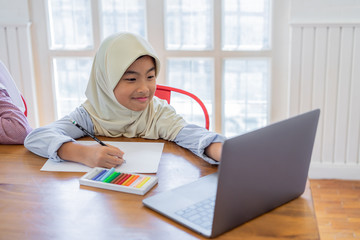 Cute asian muslim students doing homework in classroom. Back to school concept.