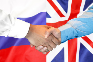 Business handshake on the background of two flags. Men handshake on the background of the United Kingdom and Russia flag. Support concept