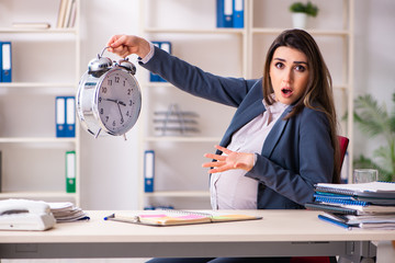 Young pregnant woman working in the office 
