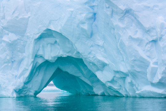 Beautiful Turquoise Blue Iceberg Floating In The Antarctic, Against A Foggy Background