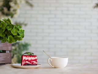cake in red and white and a Cup of tea on the table in front of the wall