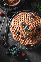 Sweet waffles made of cocoa with fresh berries