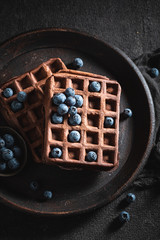 Yummy waffles with dark chocolate and fresh blueberries