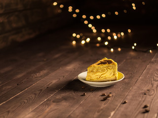 pancake cake with cream and coffee on a white saucer