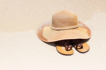 Straw hat and shoes on the beach in summer,Concept summer and beach