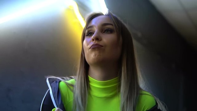 Fashionable girl dancing on the background of the neon lapms