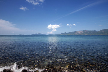 Idyllic crystal seawater in front of luxury hotel, attractive clear sea, nature coastline backgrounds during holidays, wave from clear blue green sea and fine sand