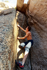 rock climber climbs a boulder over a rock without insurance