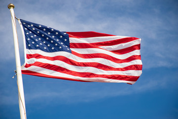 Obraz premium american flag waving in the wind against blue sky
