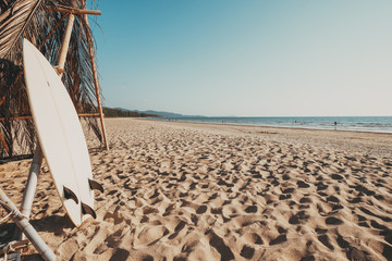 Surfboard on sand tropical beach with seascape calm sea and sky background. summer vacation...