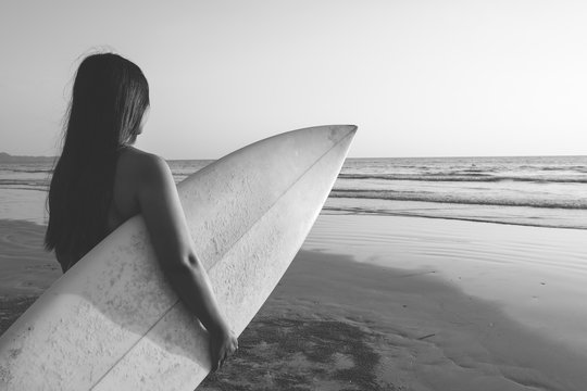 Nostalgia and remembrance photo of surfer woman in bikini go to surfing. beautiful sexy woman with surfboard on beach. black and white color tone.