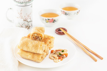 Traditional Chinese tortillas filled - bings in a plate with mushrooms on a white background, cups of tea. Copy space