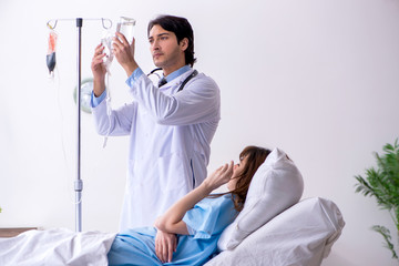 Obraz premium Male doctor visiting female patient in ward 
