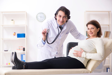 Obraz premium Old pregnant woman visiting young male doctor 