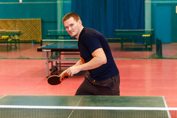 thirty-year-old man holding a racket for table tennis
