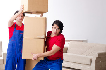Two young contractor employees moving personal belongings