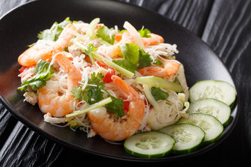 Spicy Yum Woon Sen salad with shrimps, pork and vegetables close-up on the table. horizontal