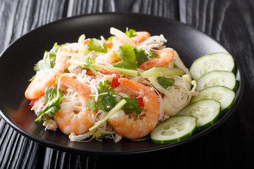 Delicious Thai salad Yum Woon Sen with seafood and vegetables close-up on a plate. horizontal