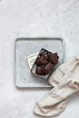 chocolate candy with nuts and dates in gift box on white marble background with copy space