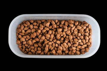 Dry cat food in a convenient home airtight container on a black background, isolate