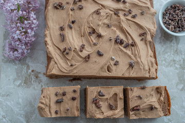 Chocolate Brownie with salted caramel frosting, cacao nibs and fresh lilac