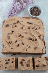 Chocolate Brownie with salted caramel frosting, cacao nibs and fresh lilac