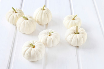 Baby boo pumpkins on white wooden table