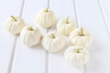 Baby boo pumpkins on white wooden table