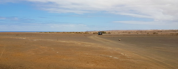A truck on a winding road through the desert on the small island of Sal, belonging to the Islands of Cape Verde