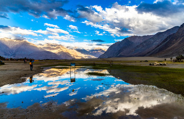 Reflection of mountain and sky with mountain and clear blue sky with passing clouds in Leh-Ladakh