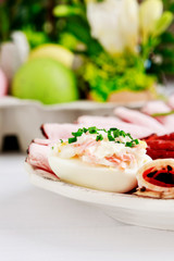 Plate with sliced ham and stuffed eggs.