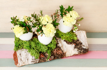 Easter decoration with egg shell, carnation flower, buxus, chamelaucium and moss