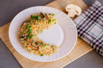 White plate with spicy pilaf with mushrooms