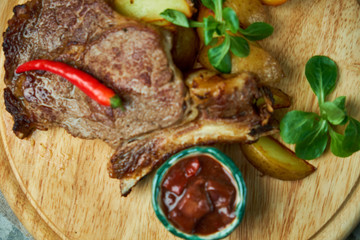 Bone loin with potatoes and basil, red sauce