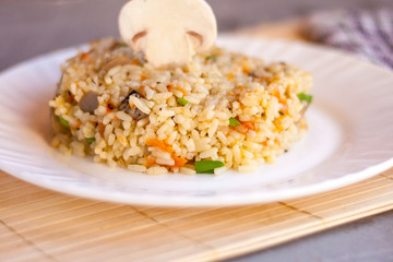 White plate with spicy pilaf with mushrooms